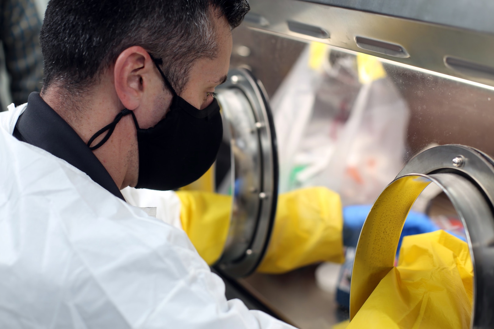 Maj. Wes Watson, commander of the Washington National Guard's 10th Civil Support Team, tests a COVID-19 collection sample in the mobile laboratory on behalf of the Washington Department of Health on Jan. 5, 2021, in Shoreline, Wash.