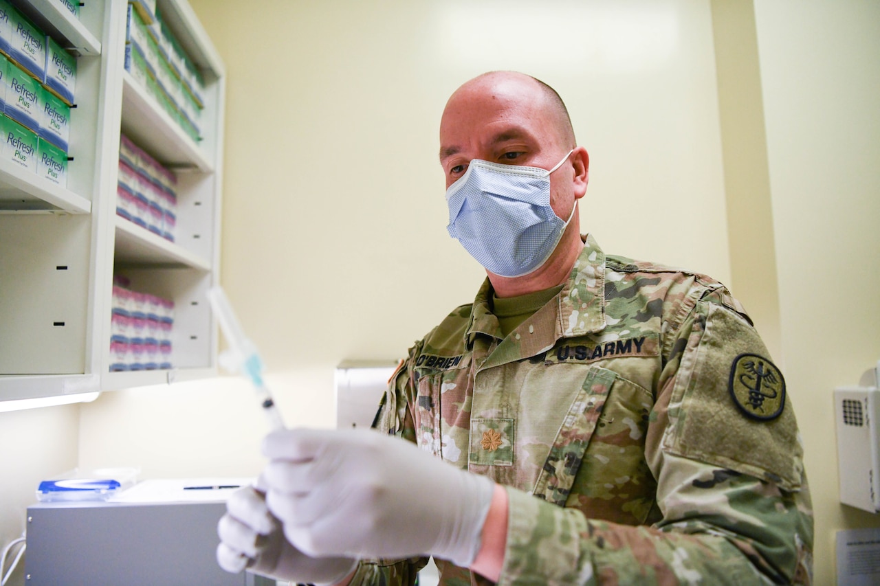 A soldier handles a vaccine.