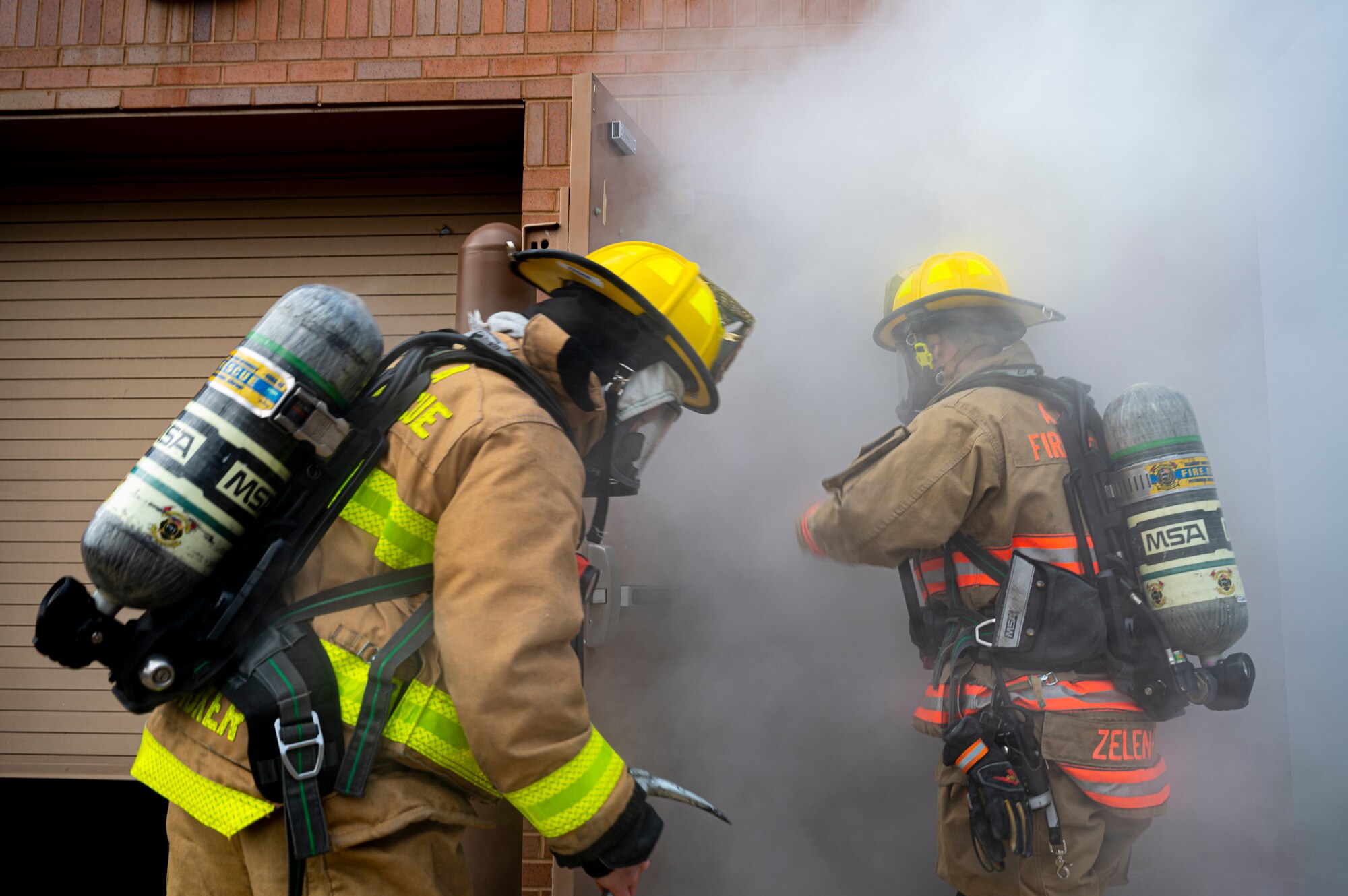 Alexis Pihoker and Adam Zelenko, Allegheny County Airport Authority firefighters, enter a smoke-filled munitions storage area during a fire drill at the Pittsburgh International Airport Air Reserve Station, Pennsylvania, Dec. 10, 2020.