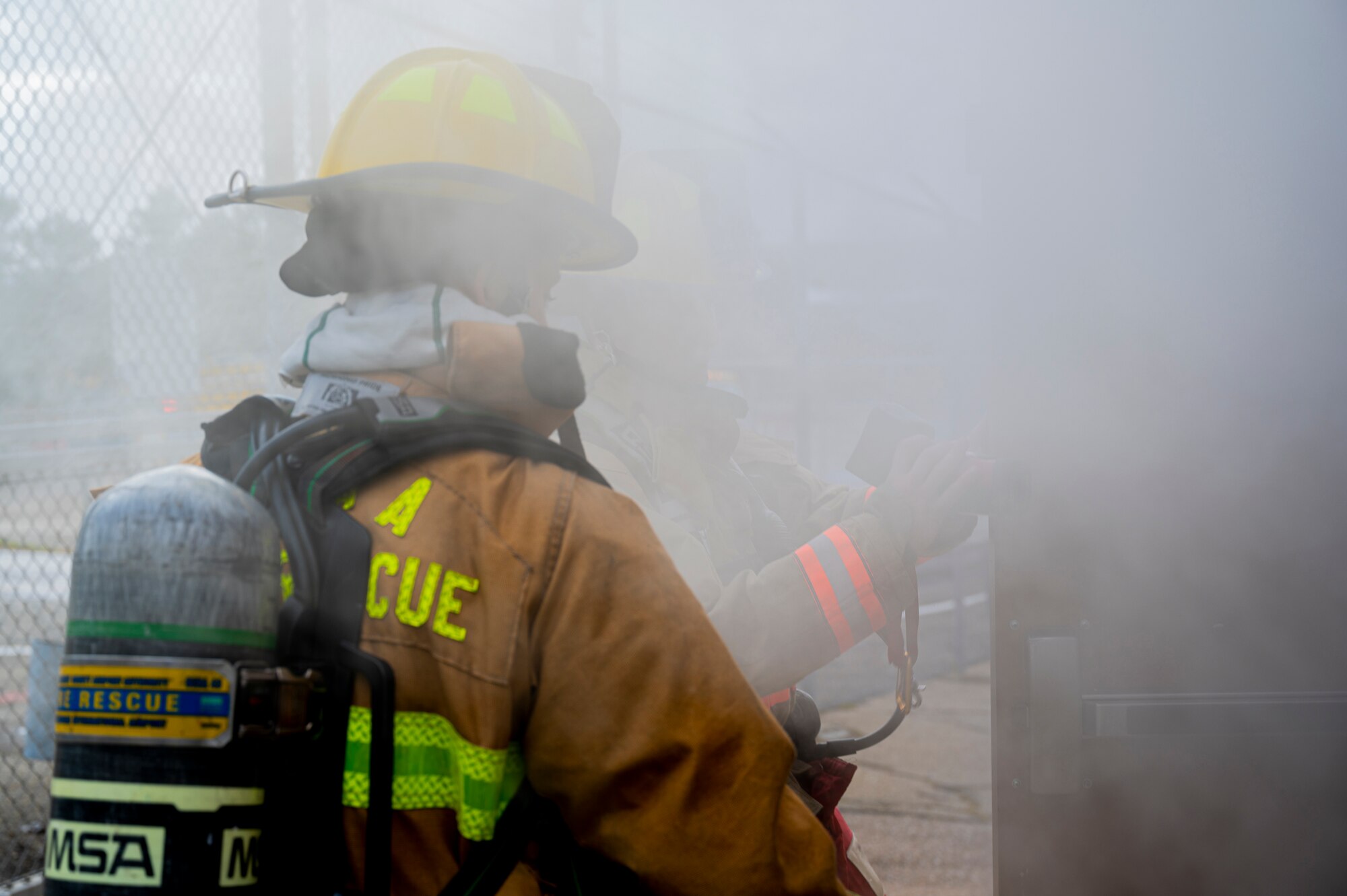 Alexis Pihoker and Adam Zelenko, Allegheny County Airport Authority firefighters, survey the inside of a munitions storage area during a fire drill at the Pittsburgh International Airport Air Reserve Station, Pennsylvania, Dec. 10, 2020.