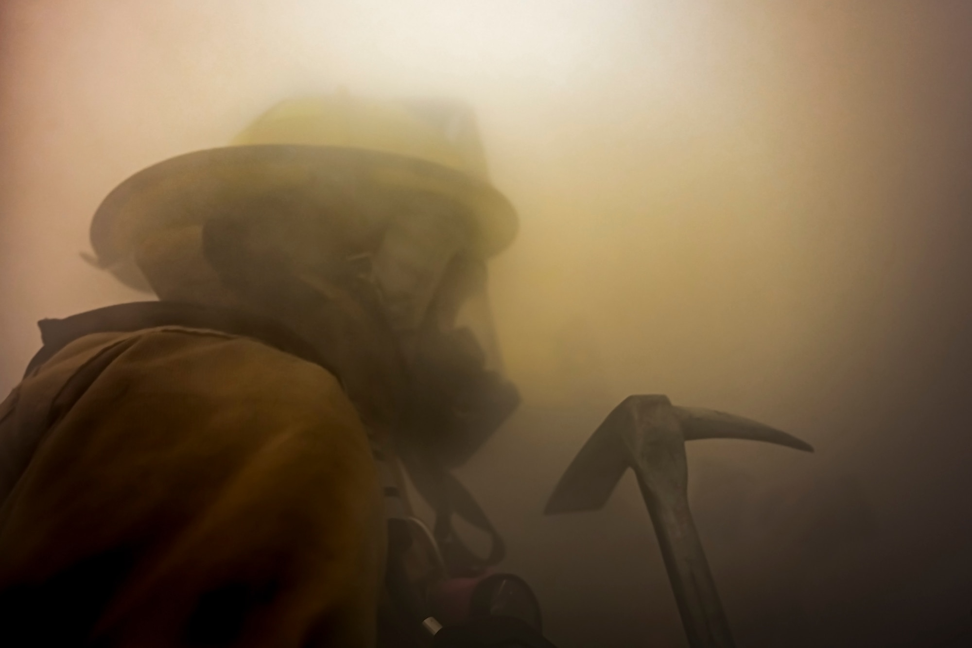 Alexis Pihoker, Pittsburgh Airport Authority firefighter, walks through a smoke-filled room searching for people in need of rescue during a munitions storage area fire drill at the Pittsburgh International Airport Air Reserve Station, Pennsylvania, Dec. 10, 2020.