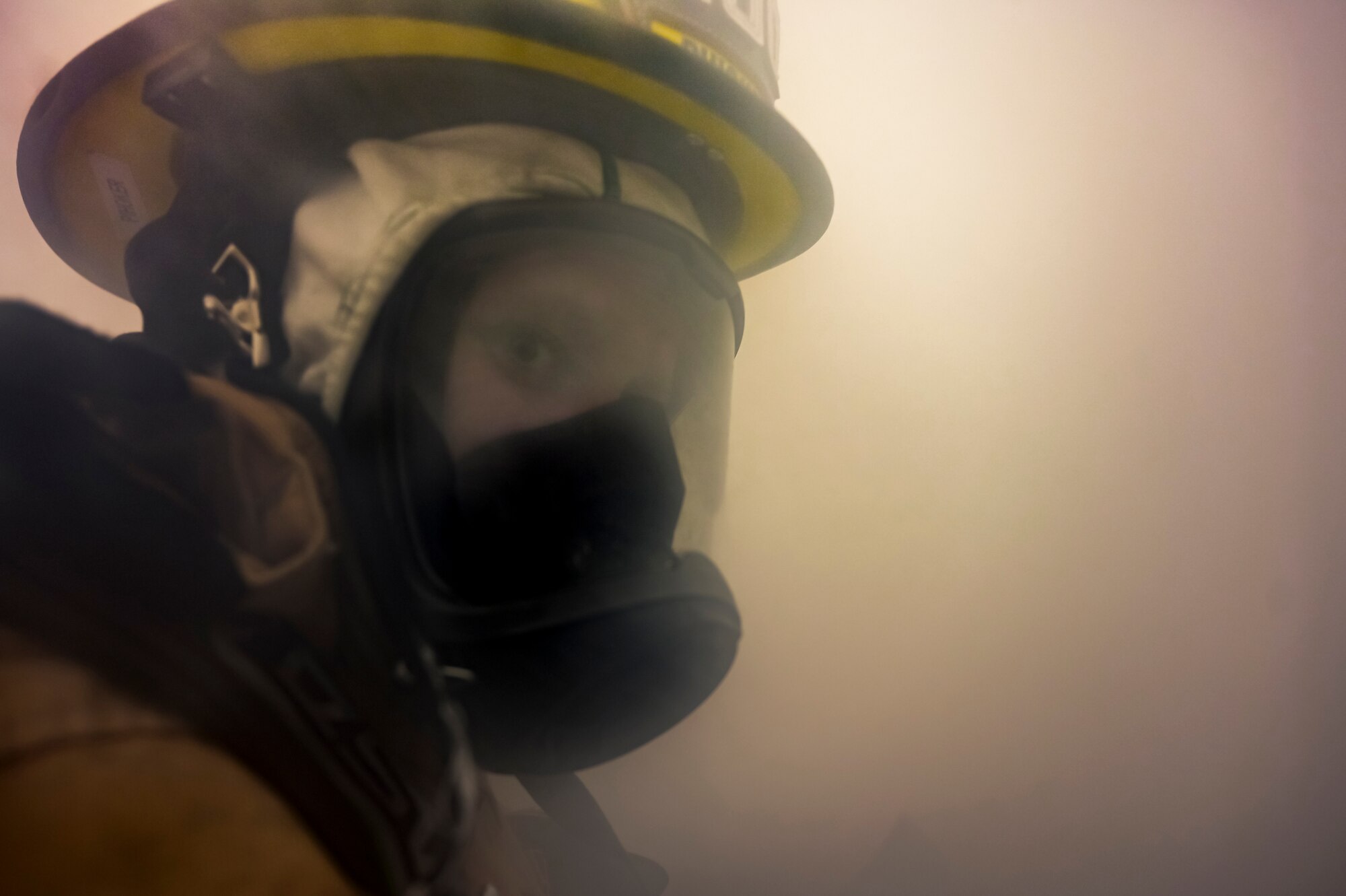 Alexis Pihoker, Pittsburgh Airport Authority firefighter, walks through a smoke-filled room searching for people in need of rescue during a munitions storage area fire drill at the Pittsburgh International Airport Air Reserve Station, Pennsylvania, Dec. 10, 2020.