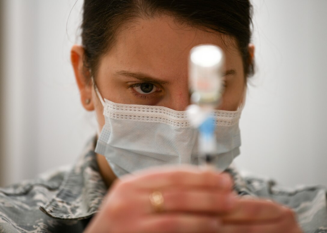 U.S. Air Force Staff Sgt. Anna Murray, 48th Medical Group immunizations technician, draws the COVID-19 vaccine from a vial at Royal Air Force Lakenheath, England, Jan. 6, 2021. Initial vaccines will be limited to healthcare workers, first responders, and other essential personnel to assess the process and will be used to plan an expanded distribution phase, where each service will request and administer the vaccine through a Defense Department wide phased vaccination approach. (U.S. Air Force photo by Senior Airman Madeline Herzog)