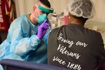 Michigan Army National Guard Spc. Ethan Ash, 1st Battalion, 182nd Field Artillery Regiment, administers COVID-19 vaccinations to residents and employees of the Grand Rapids Home for Veterans, Grand Rapids, Michigan, Jan. 6, 2021.