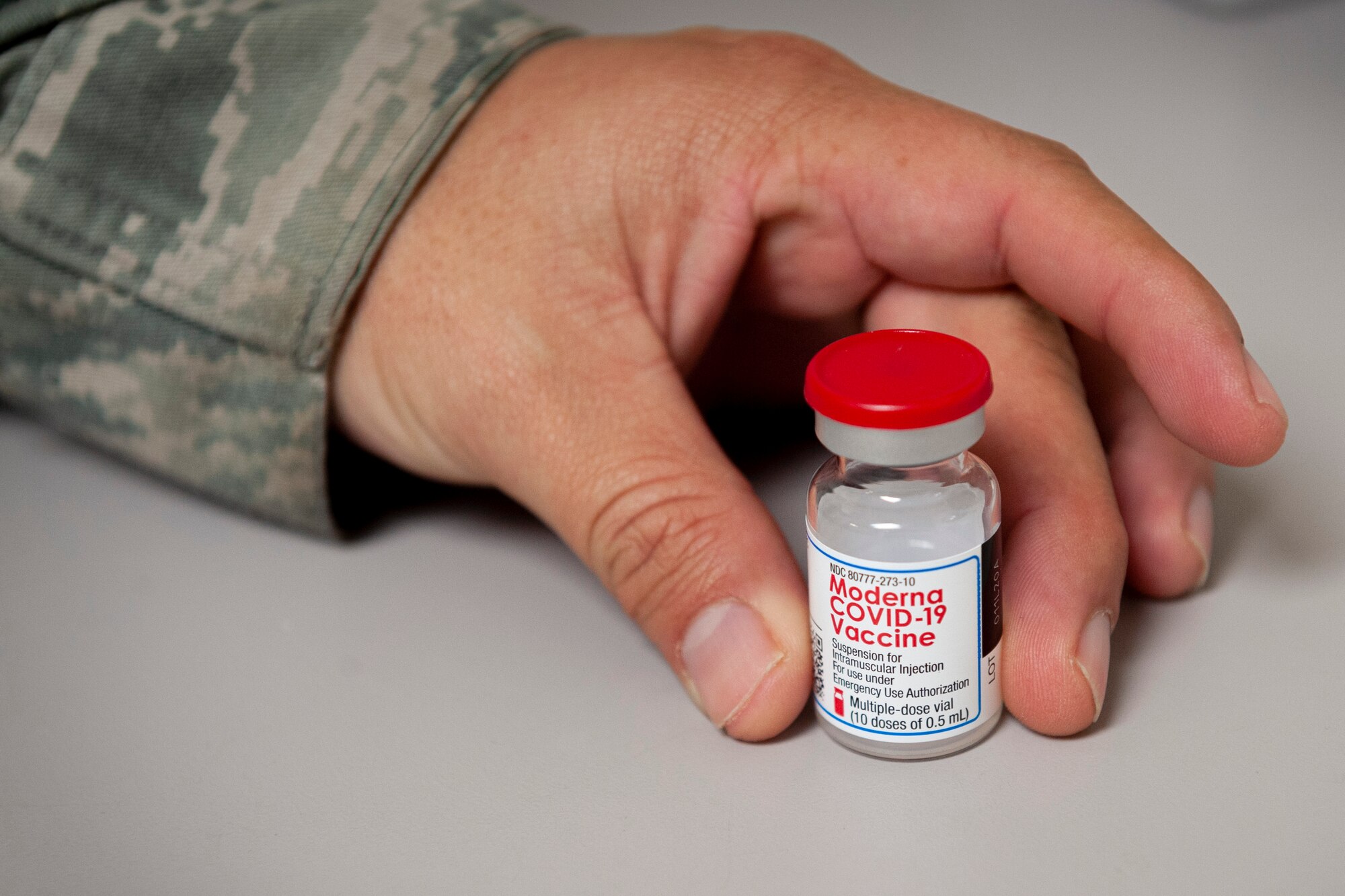 Photo of an Airman holding a vial