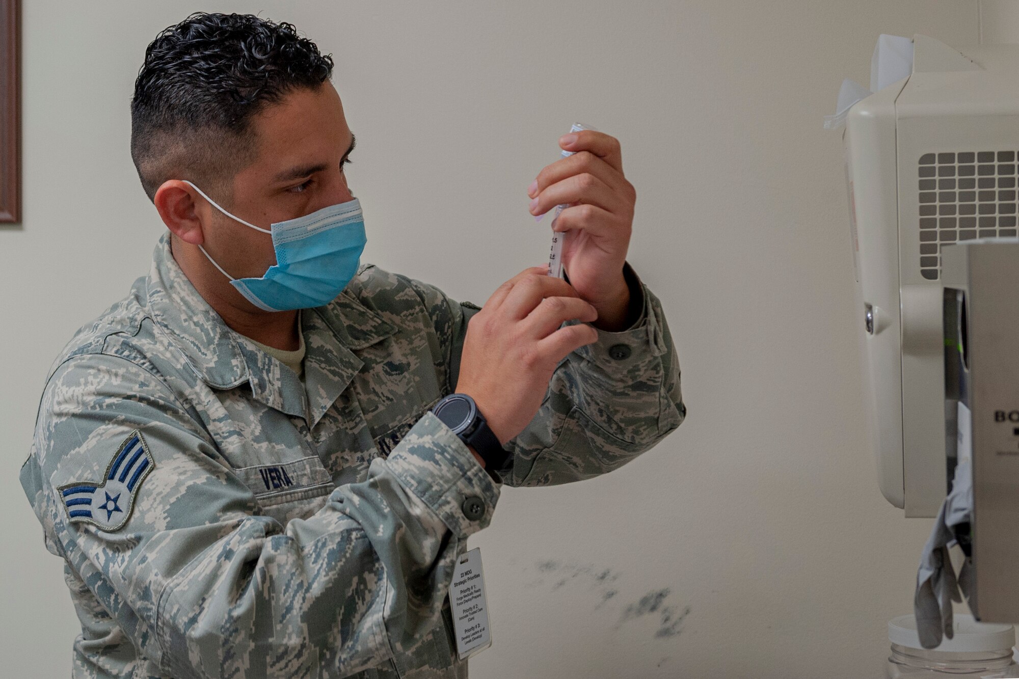 Photo of an Airman preparing to administer a vaccine