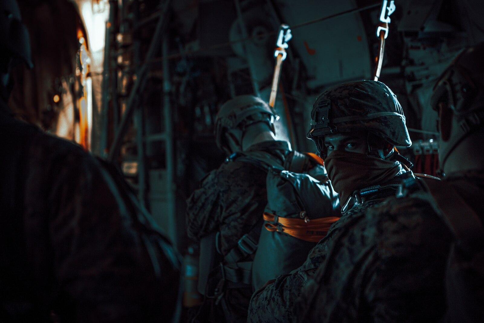 U.S. Marines with 1st Radio Battalion, I Marine Expeditionary Force Information Group, begin safety checks during a static-line jump exercise Dec. 10, 2020, from a KC-130J Super Hercules. The exercise allowed Marines of 1st Radio Battalion to practice an airborne deployment with cargo drops and static-line jumpers at Marine Corps Base Camp Pendleton, California. (U.S. Marine Corps photo by Lance Cpl. Isaac Velasco)