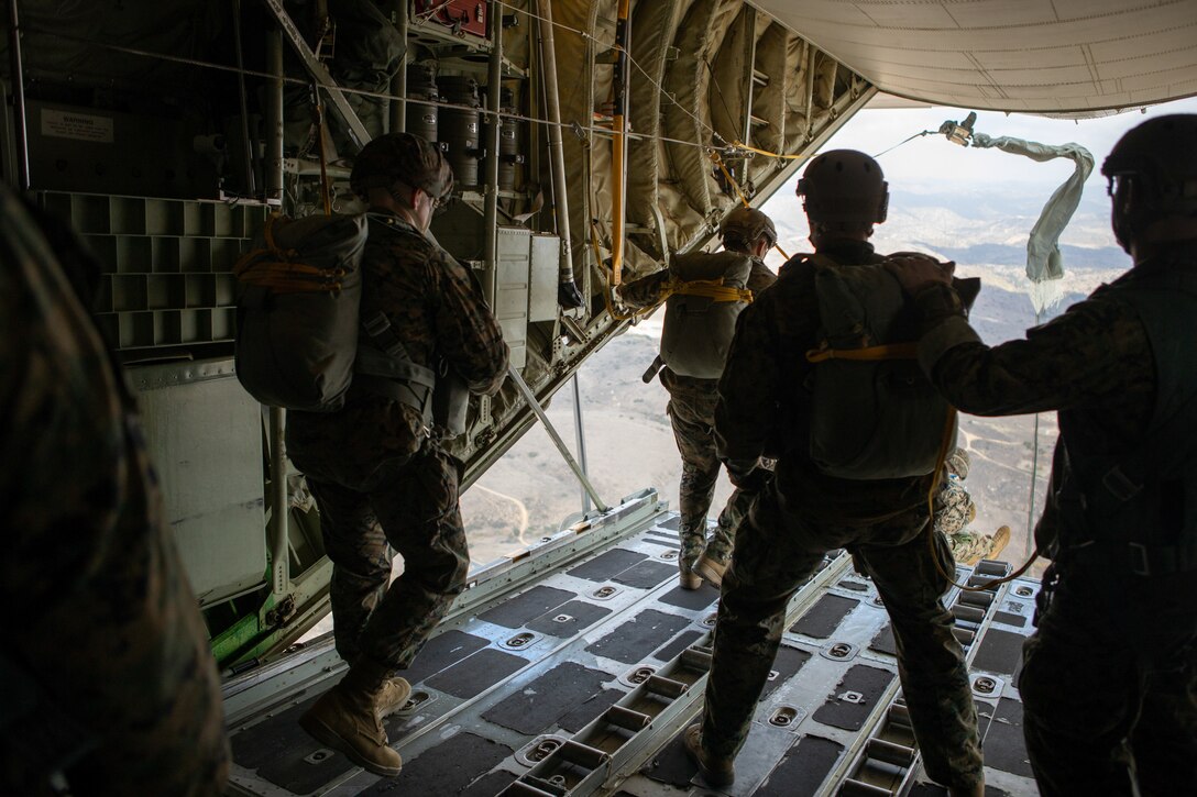 U.S. Marines with 1st Radio Battalion, I Marine Expeditionary Force Information Group, prepare to exit a KC-130J Super Hercules aircraft during a static-line parachute jump Dec. 10, 2020. The training allowed Marines of 1st Radio Battalion to practice an airborne deployment with cargo drops and static-line jumpers at Marine Corps Base Camp Pendleton, California. (U.S. Marine Corps photo by Lance Cpl. Isaac Velasco)