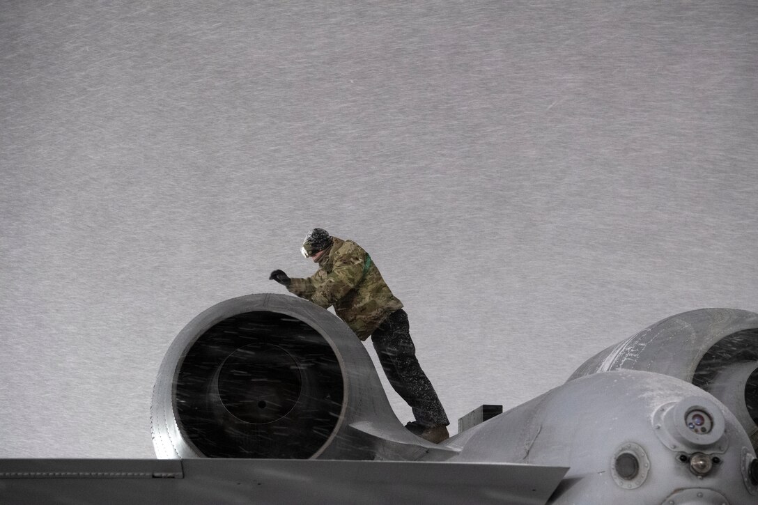 A 25th Aircraft Maintenance Unit Airman braces the cold while performing maintenance on an A-10 Thunderbolt at Osan Air Base, Republic of Korea, Jan. 6, 2021. The 25th AMU operated under frigid conditions to ensure the A-10 flying mission remains ready to “Fight Tonight.” (U.S. Air Force photo by Senior Airman Noah Sudolcan.)