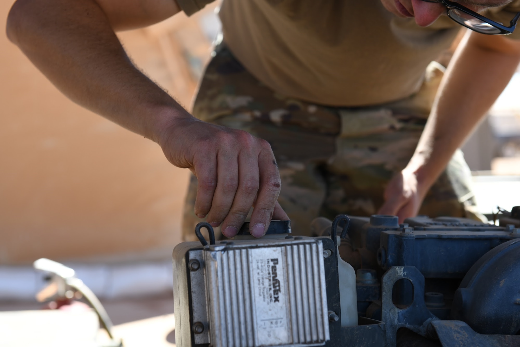 U.S. Air Force Senior Airman Ryan Davis, 724th Expeditionary Air Base Squadron air terminal operations center journeyman, replaces a cap after putting oil into a Halvorsen 25K-Loader, at Nigerien AB 201, Agadez, Niger, Jan 4, 2021. ATOC’s mission is that each plane is handled quickly and safely. (U.S. Air Force photo by Senior Airman Gabrielle Winn
