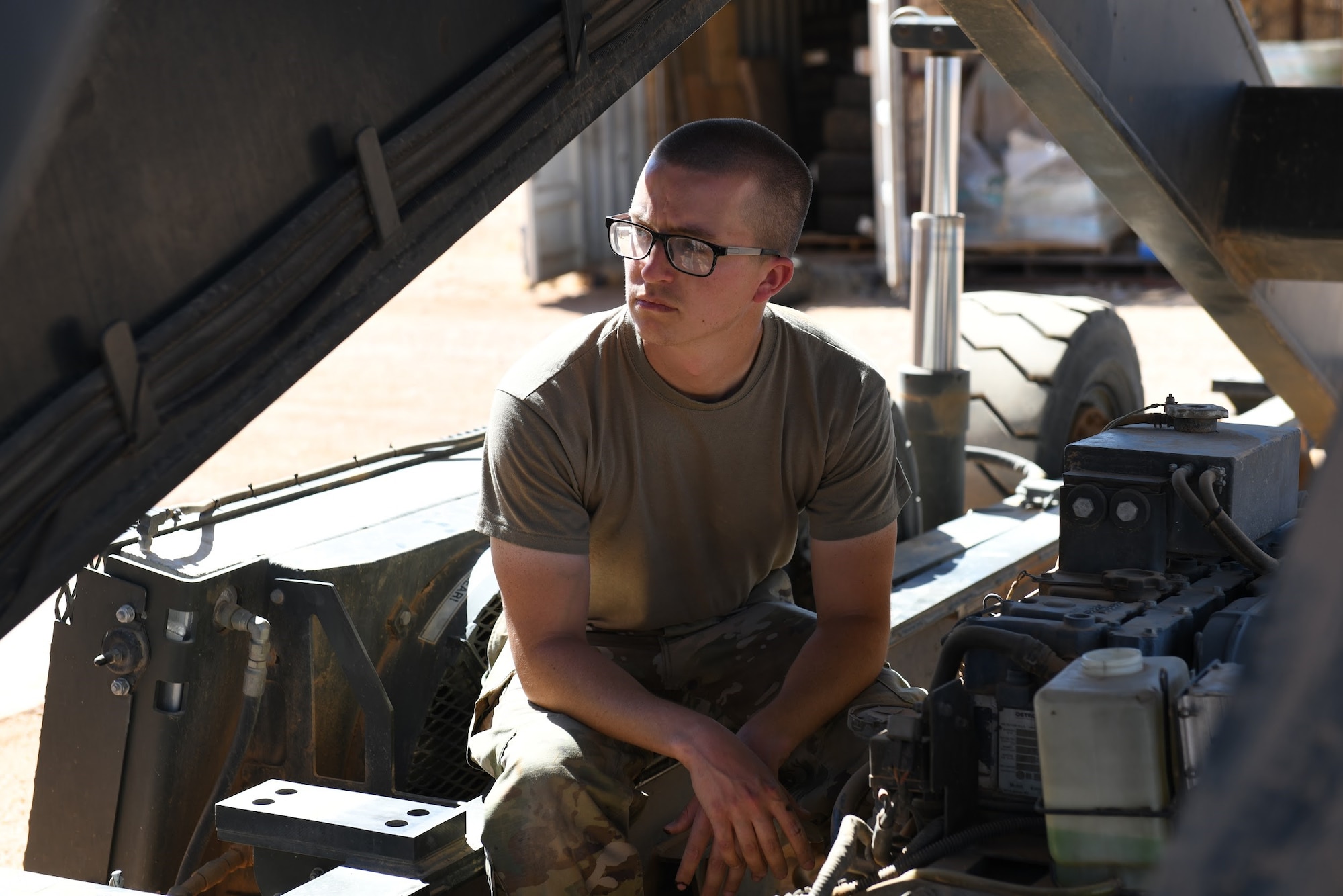 U.S. Air Force Senior Airman Ryan Davis, 724th Expeditionary Air Base Squadron air terminal operations center journeyman, cools off from the desert heat while servicing a Halvorsen 25K-Loader, at Nigerien Air Base 201, Agadez, Niger, Jan 4, 2021. ATOC’s main purpose at AB 201 is to move cargo, mail and passengers in and out of the installation ensuring cargo gets into the hands of the users and passengers get to where they need to go. (U.S. Air Force photo by Senior Airman Gabrielle Winn)