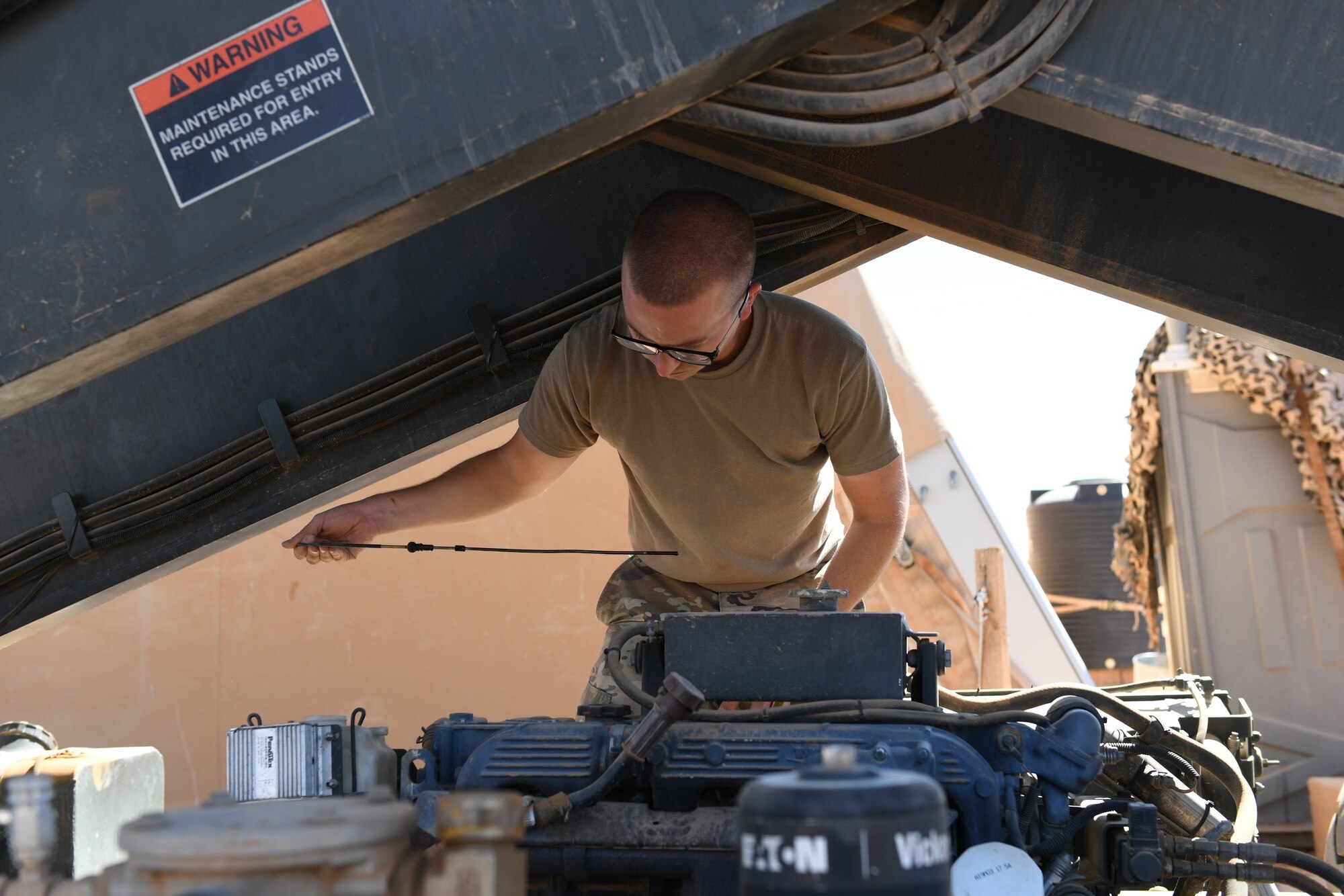 U.S. Air Force Senior Airman Ryan Davis, 724th Expeditionary Air Base Squadron air terminal operations center journeyman, checks the oil level in a Halvorsen 25K-Loader, at Nigerien Air Base 201, Agadez, Niger, Jan 4, 2021. ATOC is responsible for air transportation operations including cargo upload/download, cargo processing, special handling, passengers, and load planning. (U.S. Air Force photo by Senior Airman Gabrielle Winn)