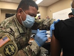 South Carolina National Guard Sgt. Alongkorn Khamkam gives a COVID-19 vaccine to a citizen at the Tidelands Waccamaw Community Hospital in Murrells Inlet, South Carolina, Jan. 7, 2021. This was the first COVID-19 vaccine administered by the SCNG to a member of the community.