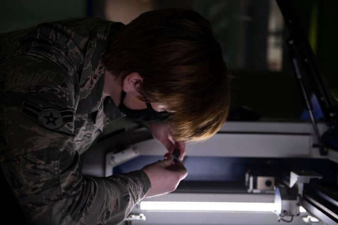 Airman 1st Class Hannah Kinter, 9th Aircraft Maintenance Squadron (AMXS) support technician, checks the quality of a laser engraving on a tool on Beale Air Force Base.