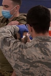 North Carolina National Guard Tech. Sgt. Matthew Prugger, an aerospace medic with the 157th Air Refueling Wing, administers the first dose of COVID-19 vaccine to a coworker at the Concord, New Hampshire, vaccination site Jan. 6, 2021.