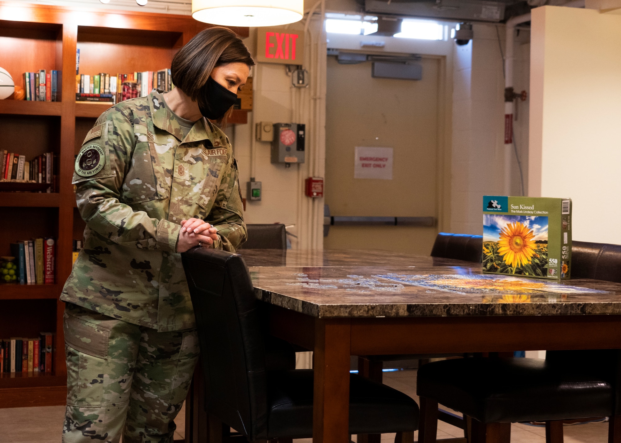 Chief Master Sgt. of the Air Force JoAnne S. Bass looks over an unfinished puzzle, Jan. 7, 2021, at Dover Air Force Base, Delaware. During her visit, Bass learned how AFMAO integrates resiliency into its day-to-day operations, in hopes of forming strong interpersonal bonds that can make a difference in Airmen’s lives. (U.S. Air Force photo by Staff Sgt. Benjamin N. Valmoja)