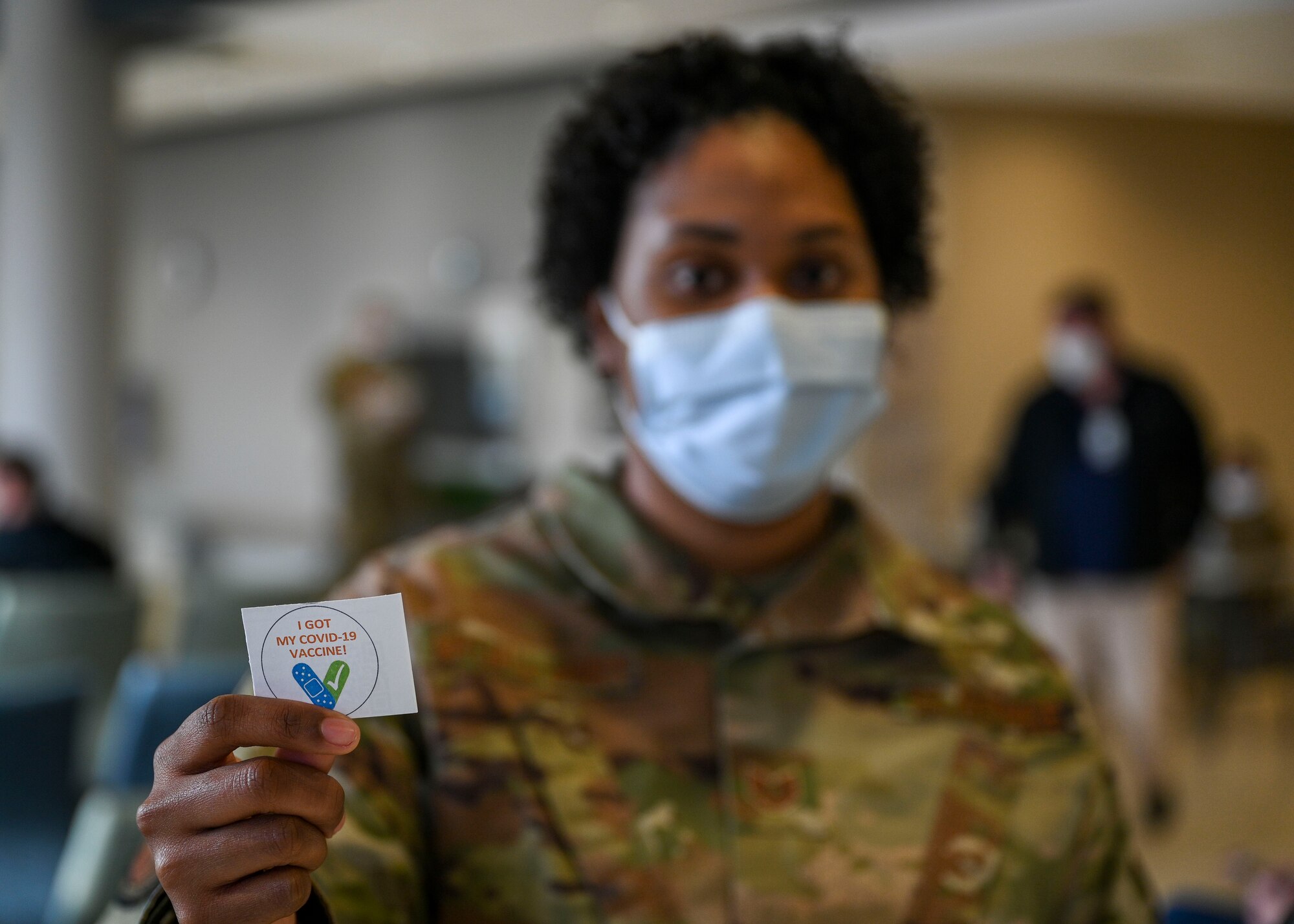 Airman posing with COVID-19 vaccine sticker