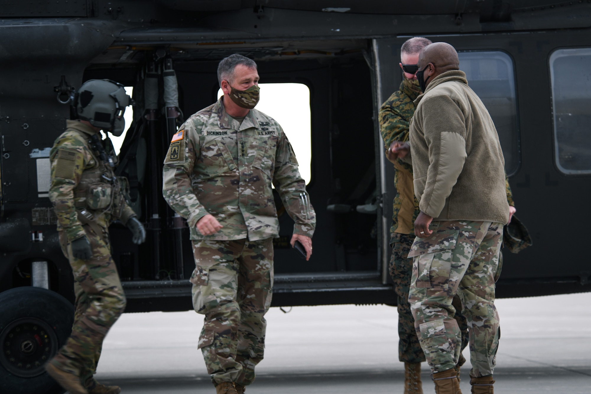 U.S. Army Gen. James Dickinson, left, U.S. Space Command commander, and U.S. Marine Corps Master Gunnery Sgt. Scott H. Stalker, USSPACECOM senior enlisted leader, are greeted by U.S. Air Force Col. Devin Pepper, far right, Buckley Garrison commander, on the flightline on Buckley Air Force Base, Colo., Jan. 7, 2021.