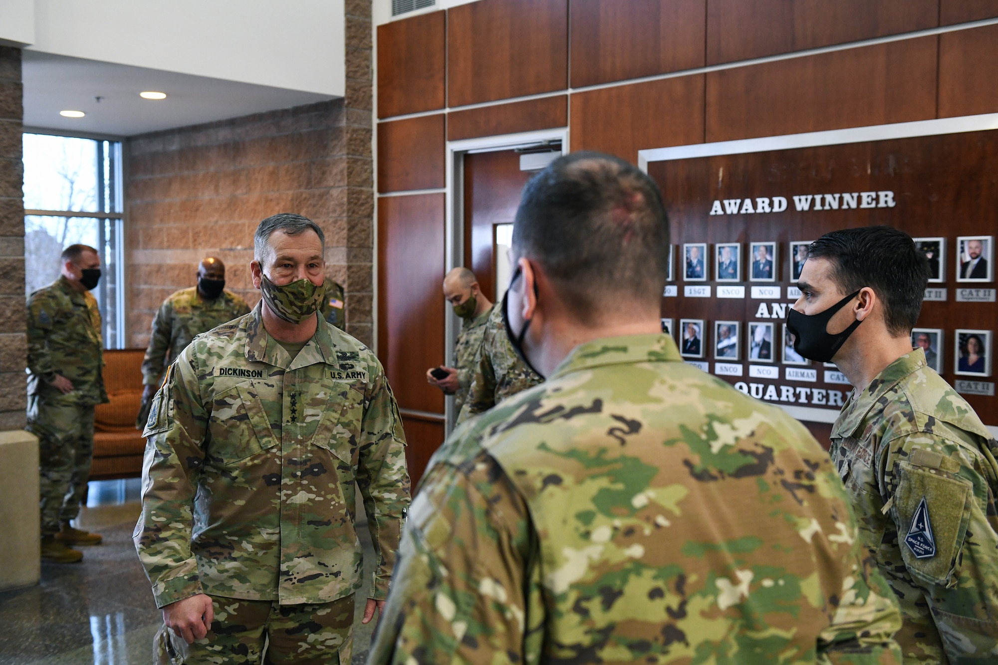 Chaplain (Maj.) Justin Combs, right, introduces Tech. Sgt. Matthew Brandt, center, Buckley Garrison Staff Agencies NCO in charge of training and readiness, prior to U.S. Army Gen. James Dickinson, left, U.S. Space Command commander, coining Brandt for exceptional performance in the Headquarters building on Buckley Air Force Base, Colo., Jan. 7, 2021.