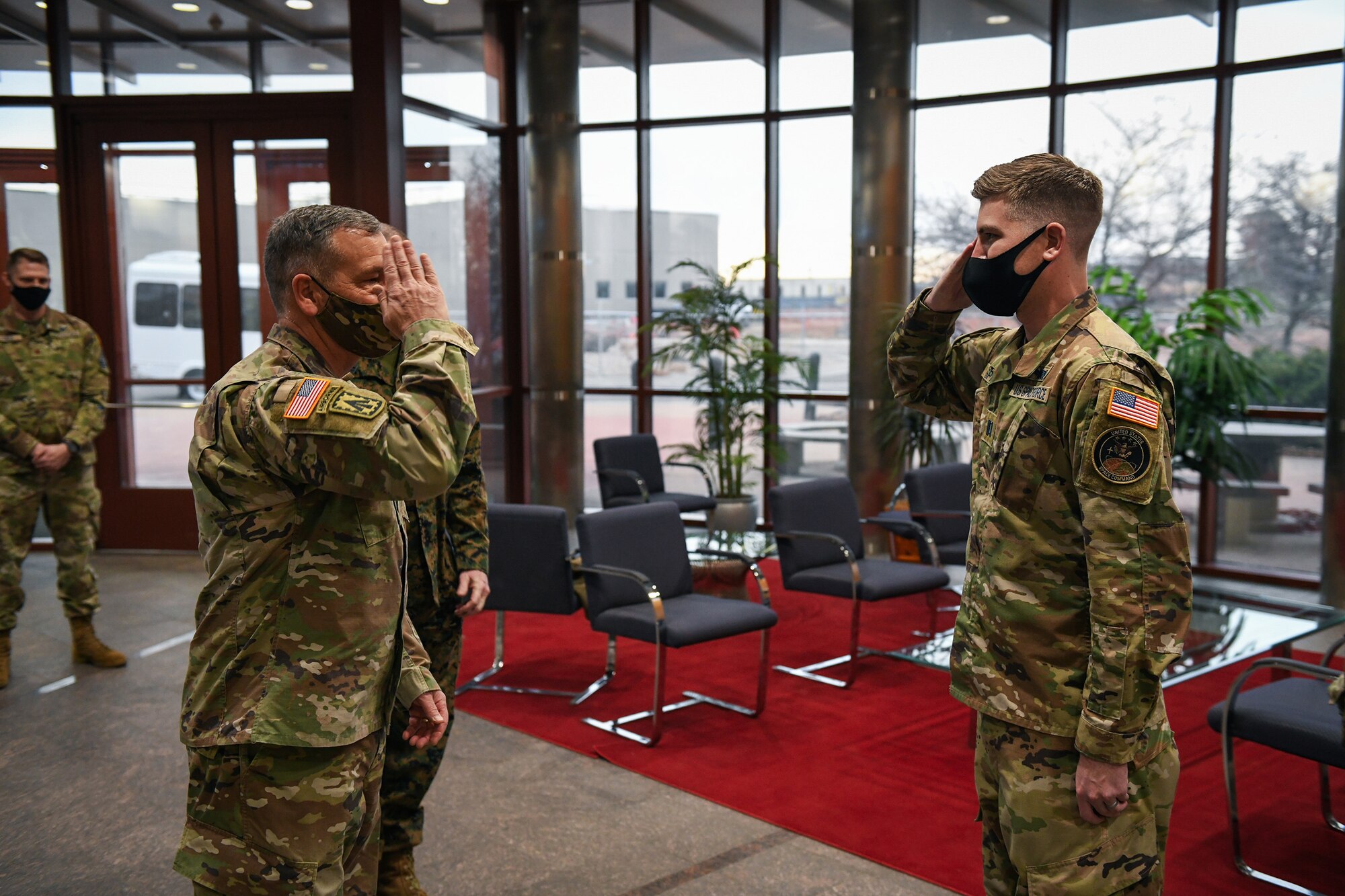 U.S. Army Gen. James Dickinson, left, U.S. Space Command commander, returns the salute of U.S. Space Force Capt. Peter Spittler, a 2nd Space Warning Squadron flight commander, after coining Spittler in the Mission Control Station lobby on Buckley Air Force Base, Colo., Jan 7, 2021.