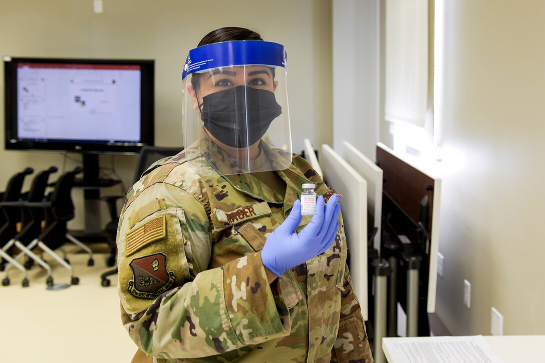 Staff Sgt. Melissa Hager, 27th Special Operations Medical Group immunizations clinic non-commissioned-officer-in-charge, holds up the COVID-19 vaccine that will be administered to active duty members at Cannon Air Force Base, N.M., Jan. 7, 2021. The vaccine distribution was handled by multiple members of the 27 SOMDG to ensure it was safely and properly delivered. (U.S. Air Force photo by Senior Airman Vernon R. Walter III)
