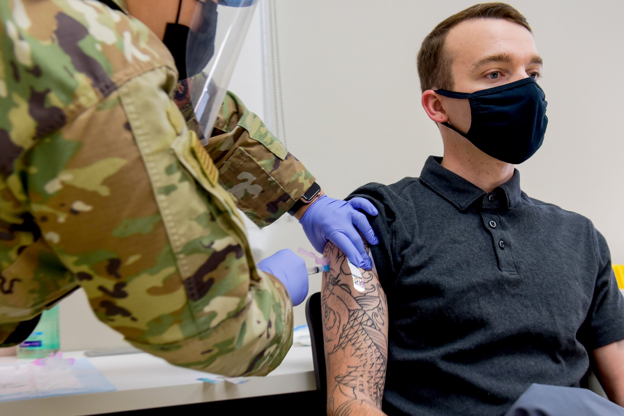 A member of the 27th Special Operations Security Force Squadron receives a COVID-19 vaccine from Staff Sgt. Melissa Hager, 27th Special Operations Medical Group immunizations clinic non-commissioned-officer-in-charge. 20 personnel were given the vaccine with more planned in the following days. (U.S. Air Force photo by Senior Airman Vernon R. Walter III)