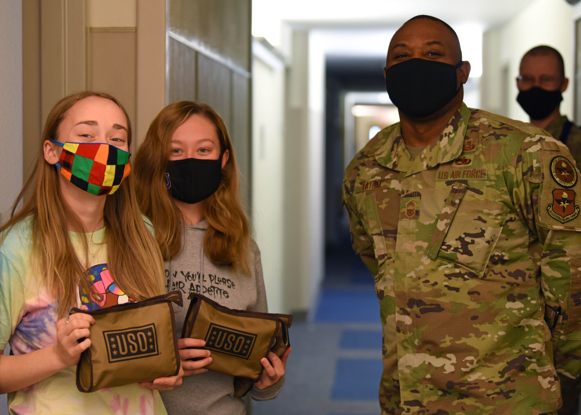 U.S. Air Force Chief Master Sgt. Charmane Tatum, 17th Training Group command chief, poses with students who have received snack packs provided by the USO at the 316th Training Squadron dorms on Goodfellow Air Force Base, Texas, Jan. 7, 2021. The USO provided snack packs for students who were quarantined after Exodus. (U.S. Air Force photo by Airman 1st Class Ethan Sherwood)