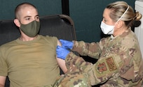 Air Force Senior Master Sgt. Jeremiah Brooks receives a COVID-19 vaccine from Air Force Lt. Col. Amber Macrae during the Vermont National Guard’s vaccine rollout Jan. 7, 2021, at Camp Johnson, Vermont. Brooks, a security forces manager with the Air National Guard’s 158th Security Forces Squadron, said he volunteered to receive the vaccine because it’s the right thing to do for his family and his squadron. Macrae is a nurse anesthetist for the ANG’s 158th Medical Group.