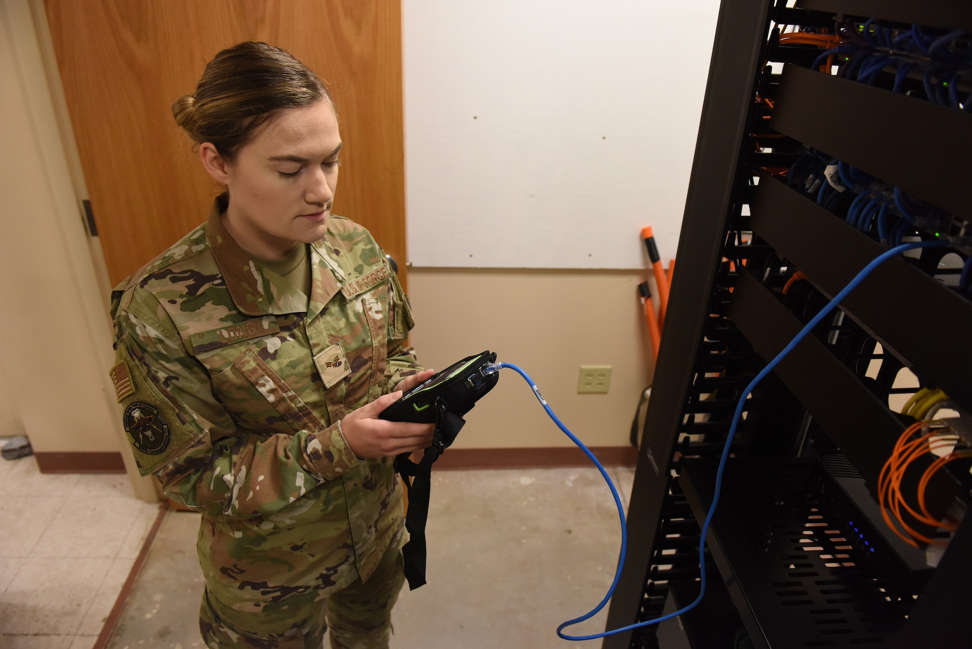 An Airman stands next to a machine.