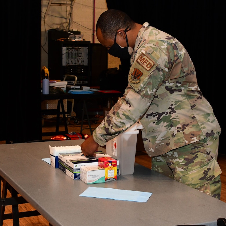 An Airman prepares a vaccination table