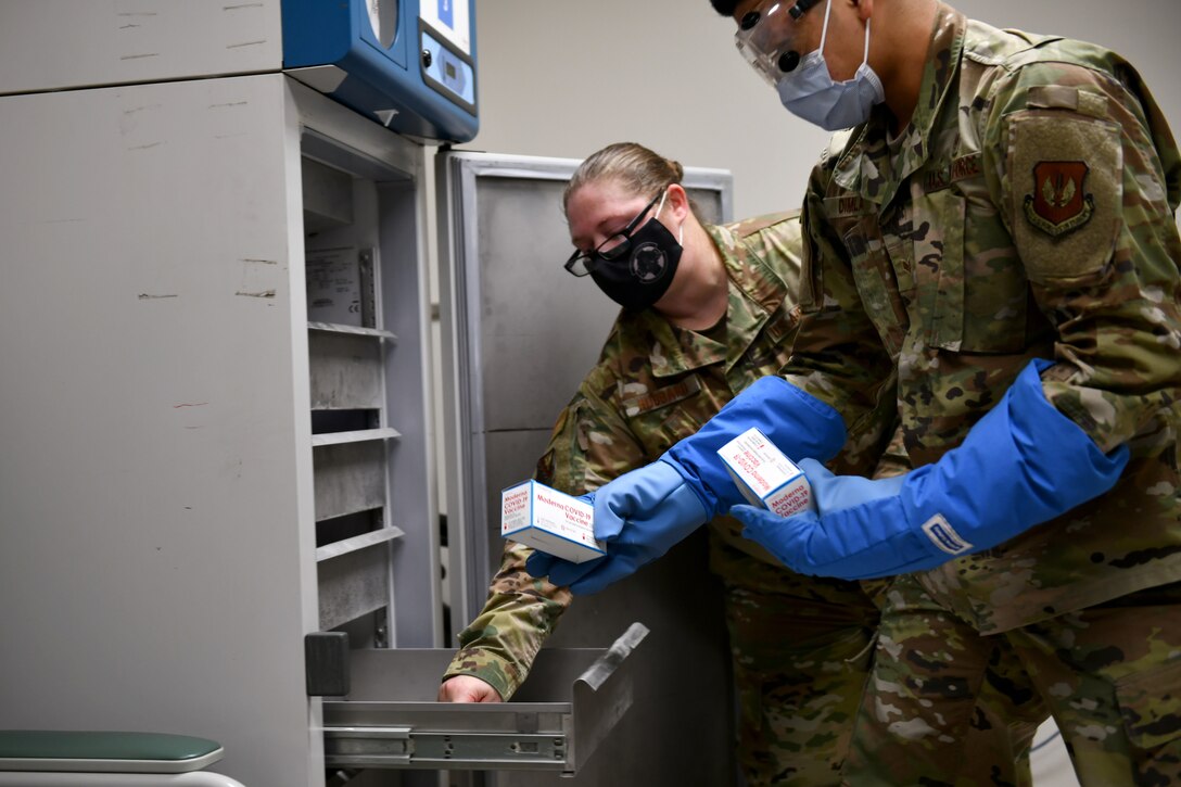 Senior Airman Siejeay Dimla, 31st Medical Support Squadron medical logistics technician, right, and Staff Sgt. Carol Hubbard, 31st Health Care Operations Squadron immunizations technician, left, place boxes of Moderna COVID-19 vaccines inside a freezer at Aviano Air Base, Italy, Jan. 7, 2021. Initial quantities of the vaccine are limited and will be distributed on a rolling delivery basis as more vaccines become available. (U.S. Air Force photo by Staff Sgt. K. Tucker Owen)