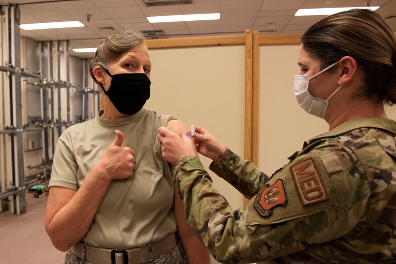 person giving a thumbs up after receiving a vaccine