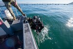Underwater Construction Team (UCT) 1, from Virginia Beach, VA, move the spill containment barrier while utilizing the Norbit Multi-beam to conduct hydro-graphic survey in Gaeta, Italy, Dec. 15, 2020.