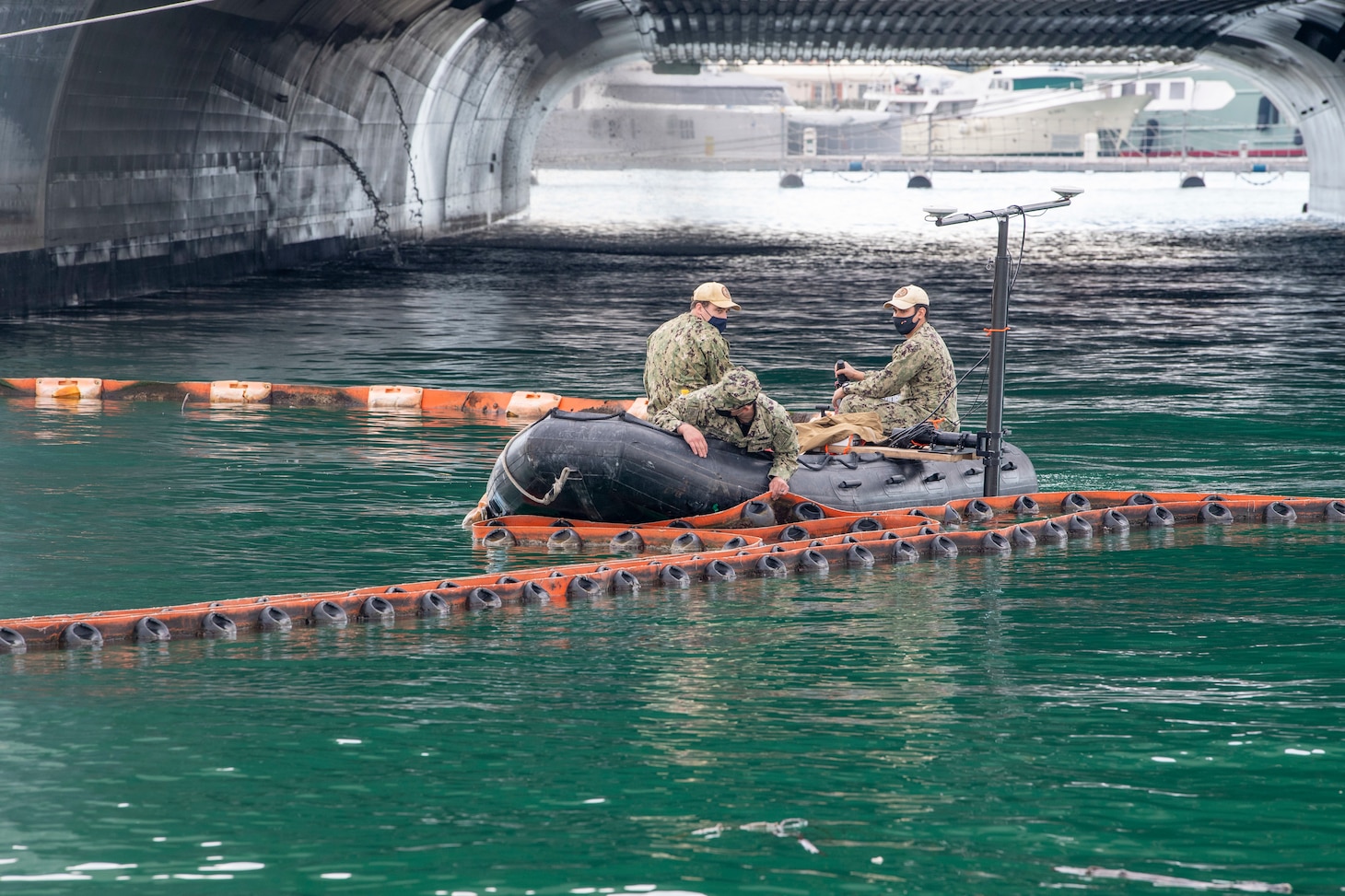 Underwater Construction Team (UCT) 1, from Virginia Beach, VA, move the spill containment barrier while utilizing the Norbit Multi-beam to conduct hydro-graphic survey in Gaeta, Italy, Dec. 15, 2020.