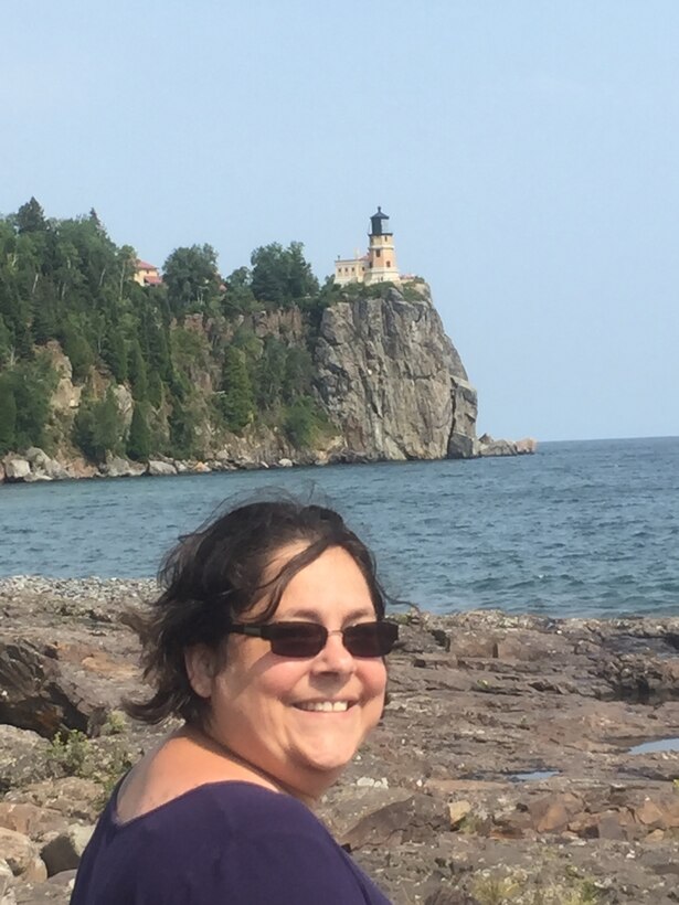 Amanda Ingram poses in front of a lighthouse.
