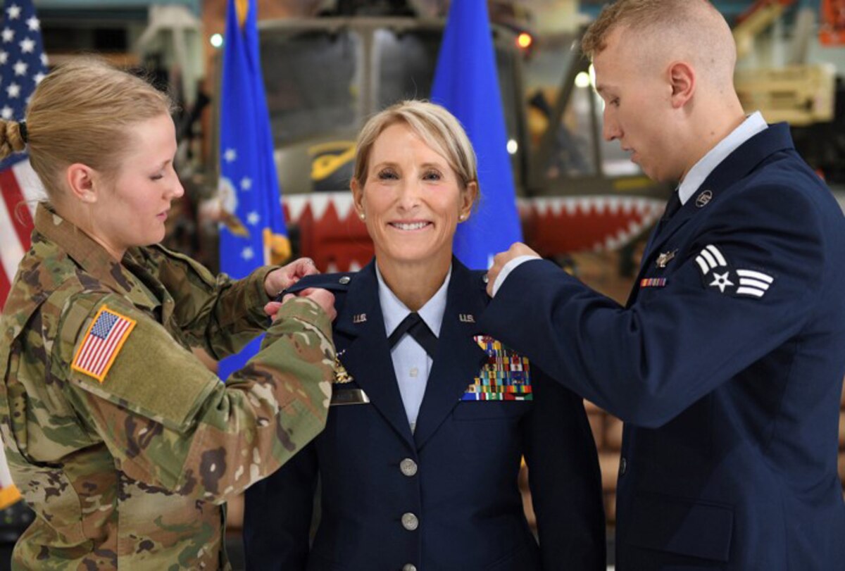 Cadet Tori Flarity and Senior Airman Patrick Flarity pin stars on their newly promoted mother, Brig. Gen. Kathleen Flarity, mobilization assistant to the command surgeon, Air Mobility Command, during a ceremony at Wings Over the Rockies Air and Space Museum, Denver, Colorado.
