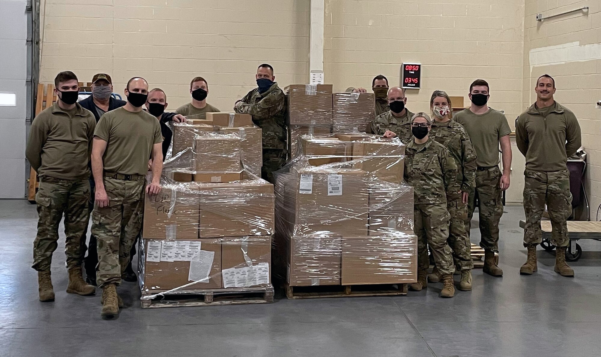 Members of the 185th Air Refueling Wing stand with some of the 11,342 pounds of food collected during the units annual food drive.