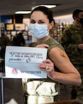 U.S. Air Force Lt. Col. Jessica Bramlette, 177th Medical Group chief of dental medicine, holds a sign stating why she is receiving a COVID-19 vaccine Jan. 9, 2021, at the 177th Fighter Wing of the the New Jersey Air National Guard, Egg Harbor Township, N.J. Members of the 177th Medical Group administered COVID-19 vaccines to 60 unit members over two days and plan to administer more soon.