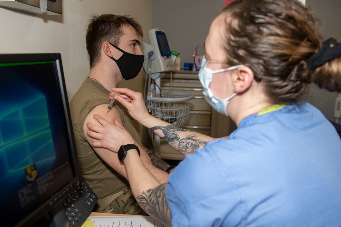 U. S. Air Force Staff Sgt. Morgan Mack, right, 423rd Medical Squadron noncommissioned officer in charge of immunization, administers the COVID-19 vaccine to a 423rd Security Forces Squadron Airman at Royal Air Force Alconbury, England, Jan. 5, 2021. 501st Combat Support Wing first responders were prioritized to receive the vaccine based on the guidance from the Centers for Disease Control and Prevention as well as the DoD COVID Task Force’s assessment of unique DoD mission requirements. (U.S. Air Force photo by Senior Airman Jennifer Zima)