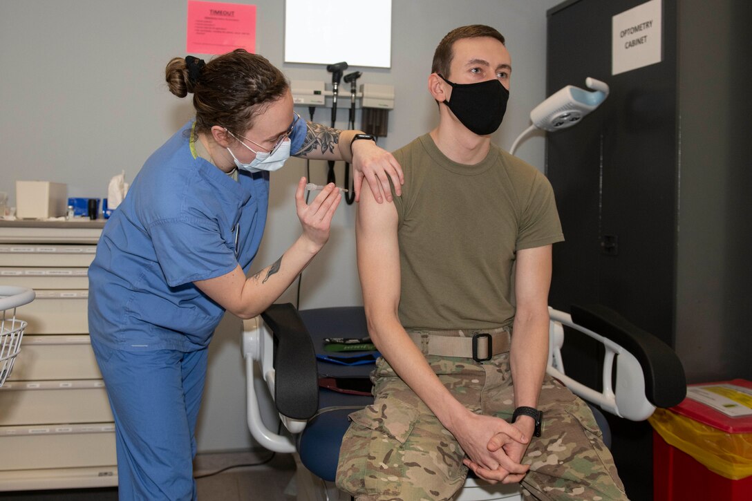 U. S. Air Force Staff Sgt. Morgan Mack, left, 423rd Medical Squadron noncommissioned officer in charge of immunization, administers the COVID-19 vaccine to a 423rd Security Forces Squadron Airman at Royal Air Force Alconbury, England, Jan. 5, 2021. 501st Combat Support Wing first responders were prioritized to receive the vaccine based on the guidance from the Centers for Disease Control and Prevention as well as the DoD COVID Task Force’s assessment of unique DoD mission requirements. (U.S. Air Force photo by Senior Airman Jennifer Zima)