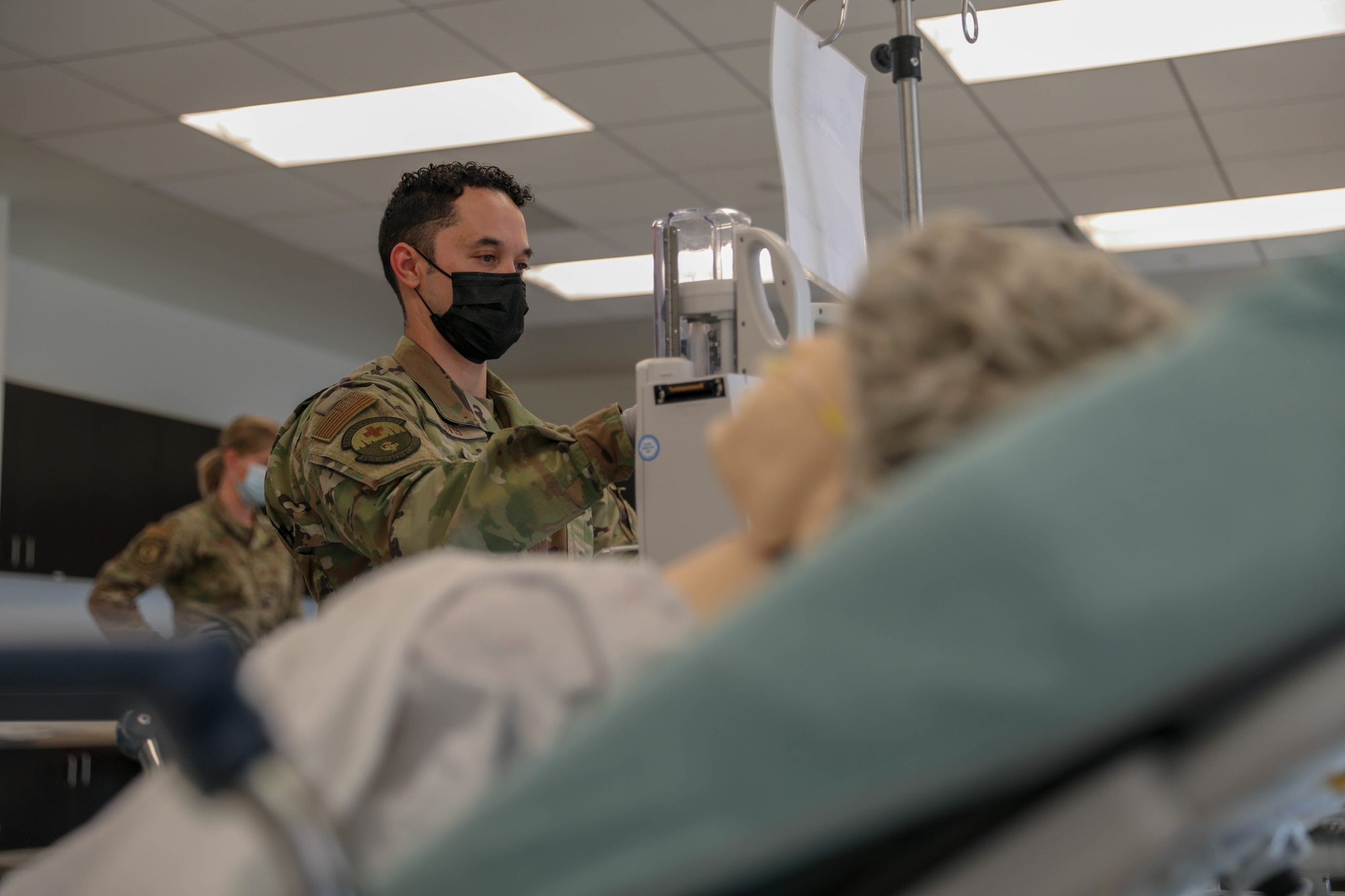 Image of a Service member helping a patient.