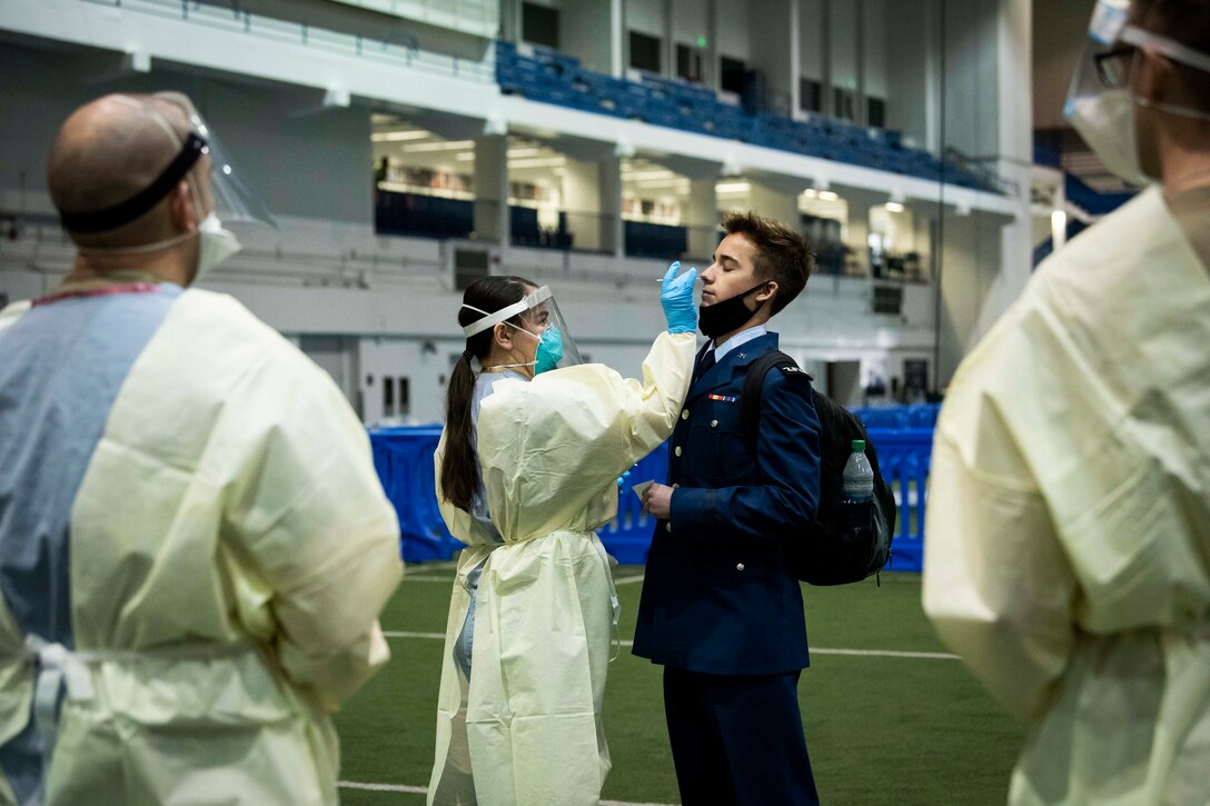 An Air Force cadet is given a COVID-19 rapid test from medical personnel wearing personal protective equipment.