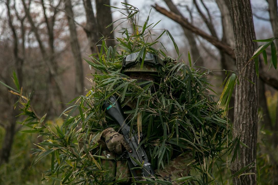 An infantryman from the 30th Infantry Regiment, 12th Brigade, Japan Ground Self-Defense Force conceals himself in mainland Japan, Dec. 14.