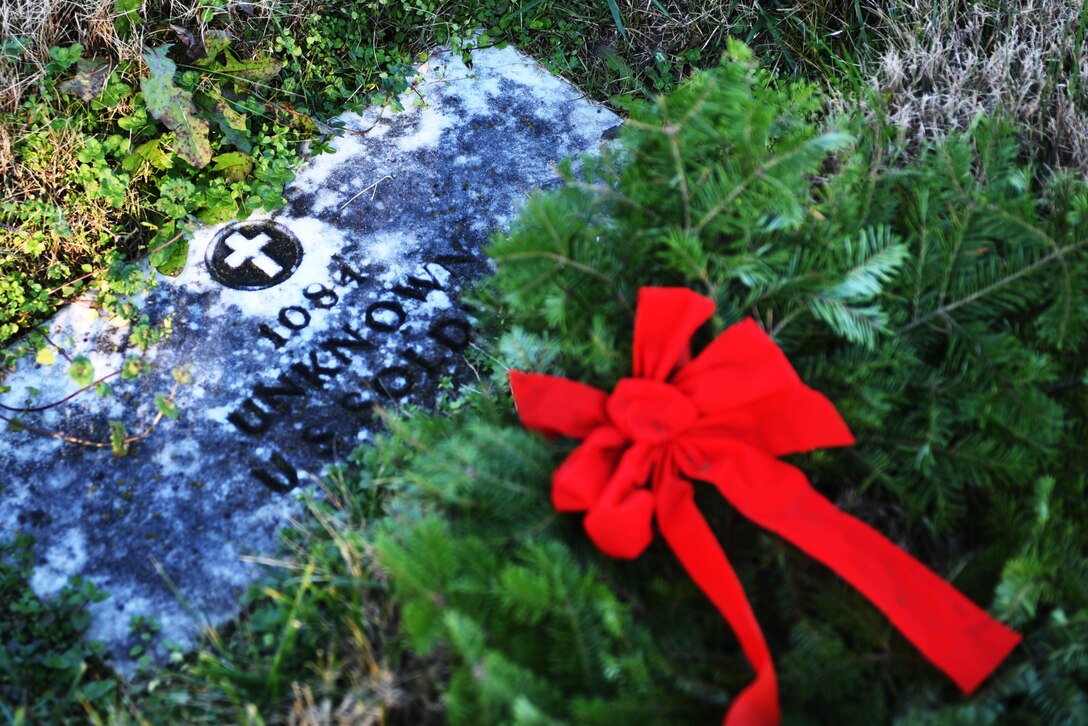 A remembrance wreath decorates the headstone of an Unknown Soldier.