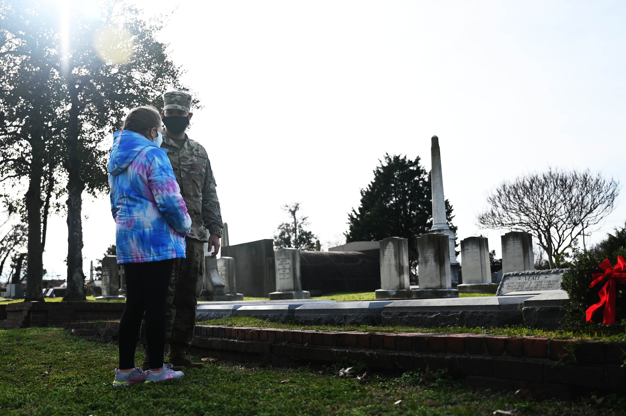 Airman stands with his daughter to commemorate fallen soldiers.