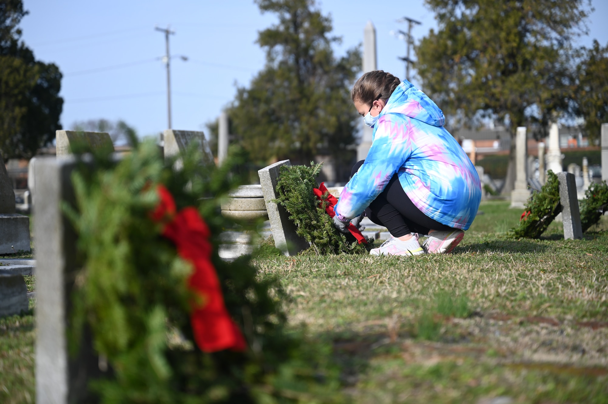 Cadence Smeltzer places a wreath over a veteran’s grave.