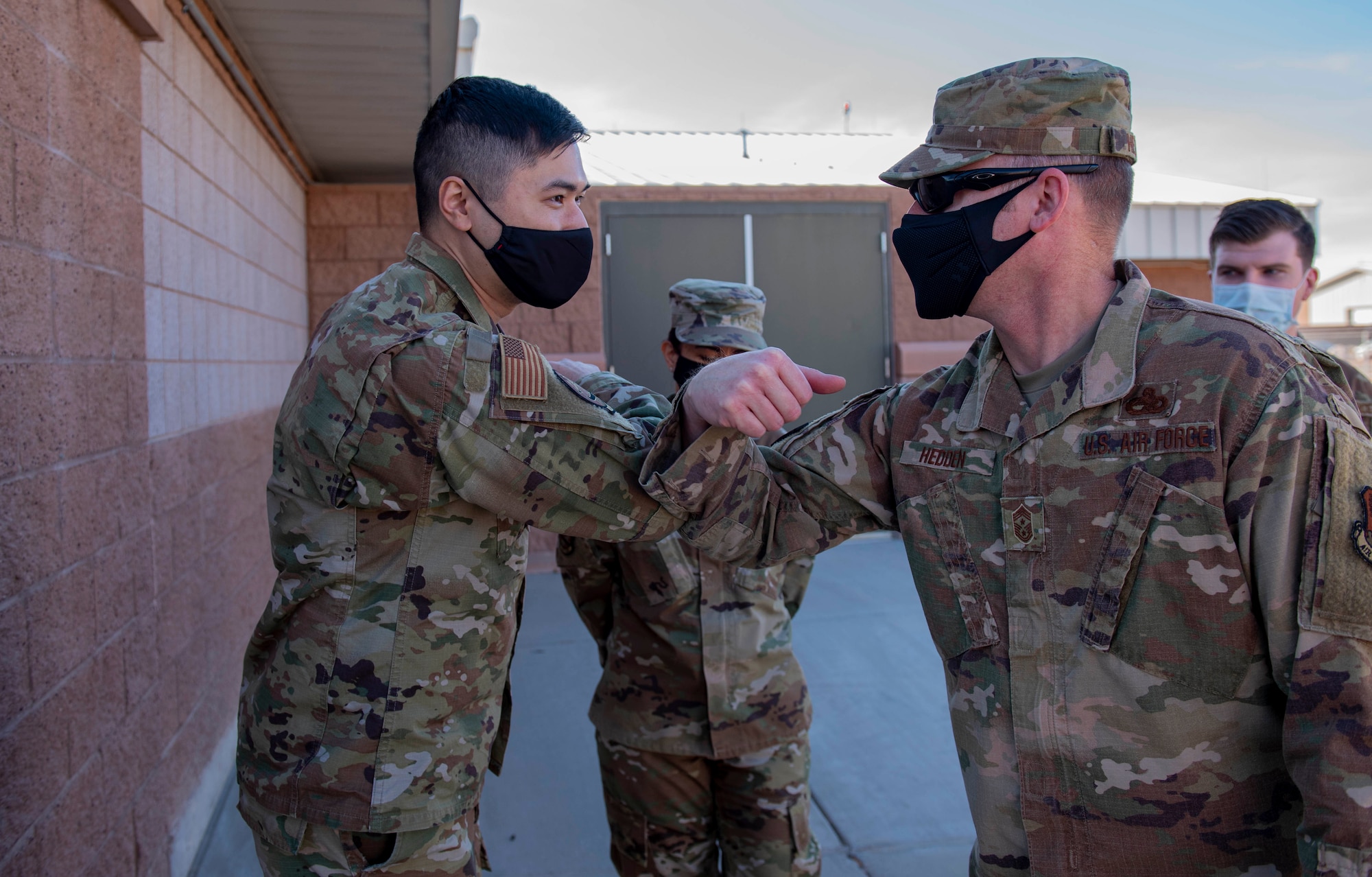 Chief Master Sgt. Benjamin W. Hedden elbow bumps 432nd Aircraft Communication Airmen during a visit.