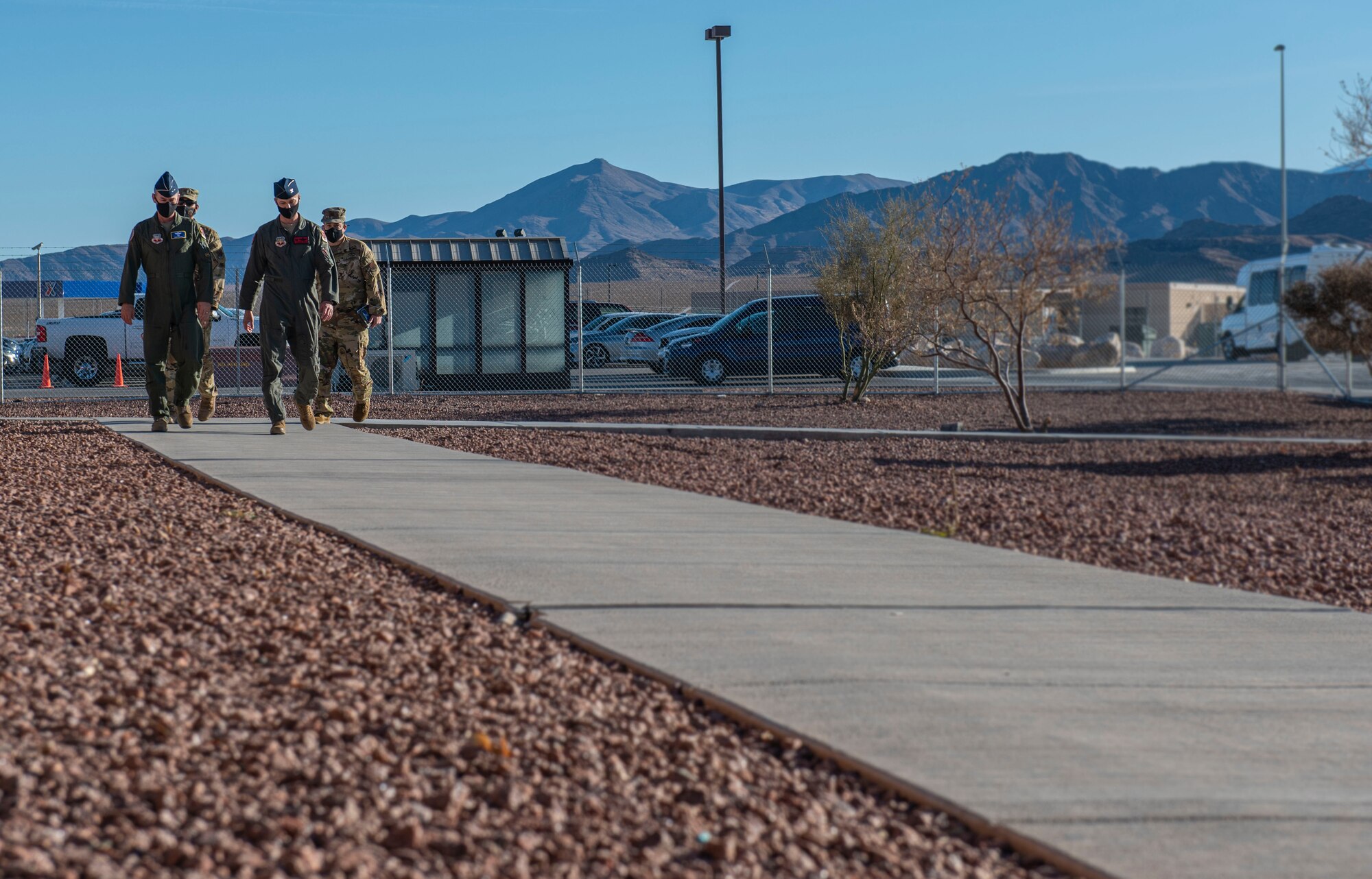 432nd Wing/432nd Air Expeditionary Wing leadership walks with Fifteenth Air Force leadership down a sidewalk.