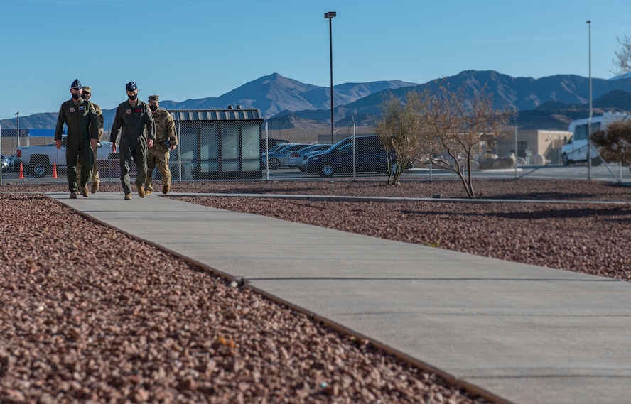 432nd Wing/432nd Air Expeditionary Wing leadership walks with Fifteenth Air Force leadership down a sidewalk.