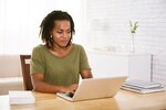 Woman smiling as you looks at her computer